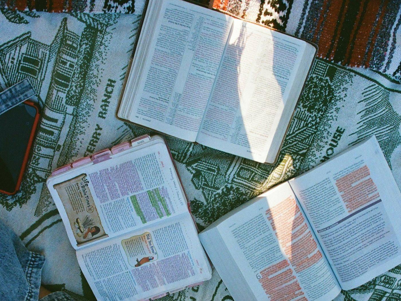 Open Bibles spread across a blanket as a group reads together